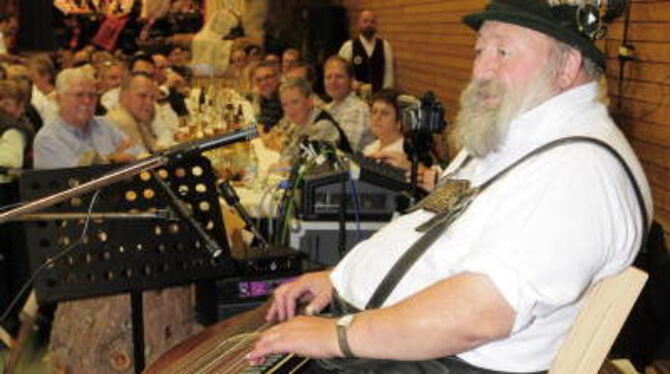 Peter Fischer sang, die Zither auf den Knien, alte, lustige G'stanzl beim erneut gelungenen Volksmusik- und Harmonika-Abend in d