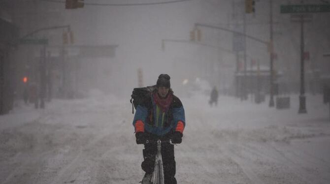 Fahrradfahren ist bei der momentanen Wetterlage an der Ostküste der USA so gut wie unmöglich - dieser Mann in New York versuc