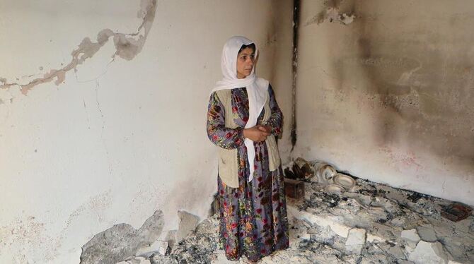 Pergüze Asan steht in Silopi (Türkei) in einem Zimmer ihres nach ihrer Aussage von Sicherheitskräften zerstörten Hauses. Foto: C