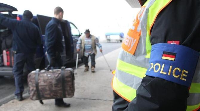 Polizisten begleiten abgelehnte Asylbewerber auf dem Flughafen Leipzig-Halle. Foto: Sebastian Willnow/Archiv