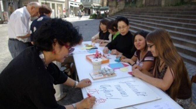 &raquo;Gedenkt unseres Opfers - Hiroshima&laquo; schreibt Sumie Kobler-Edamatsu auf ein Plakat, das sie nachher am Holzmarkt auf