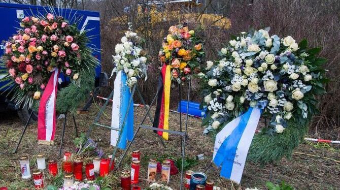 Kränze, Kerzen und Blumen liegen nahe der Unglücksstelle neben den Gleisen. Foto: Peter Kneffel