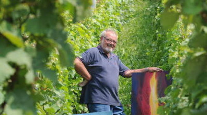 Der Maler und Wengerter dort, wo er sich am liebsten aufhält: Hans Fritz mit zwei seiner Bilder inmitten des Neuhäuser Weinbergs