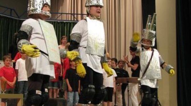 Die drei Stromfresser vor dem Schulchor beim Klima-Musical der Gustav-Werner-Schule.
FOTO: MÜLLER