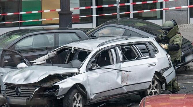 Ein Bombenentschärfer der Polizei kontrolliert den zerstörten Wagen. Foto: Paul Zinken