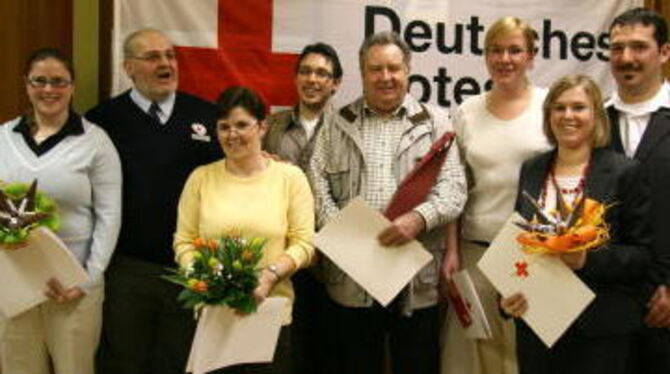 Geehrt für ihre Dienstbereitschaft (rechts DRK-Vorsitzender Timo Merz, links Kreisbereitschaftsleiter Andreas König).  FOTO: LEI