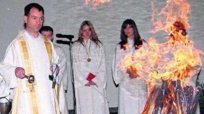 Pfarrer Werner Laub segnet im Innenhof des Gemeindezentrums St. Wolfgang in Pfullingen das Osterfeuer. 
FOTO: KABLAOUI