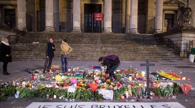 Ein Passant zündet vor der Börse am Place de la Bourse eine Kerze an. Foto: Federico Gambarini