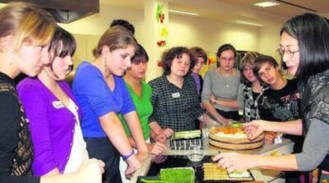 Interessiert schauen die Schüler zu, wie Shoko Quandt-Kadoya Sushi zubereitet. FOTO: SANDER