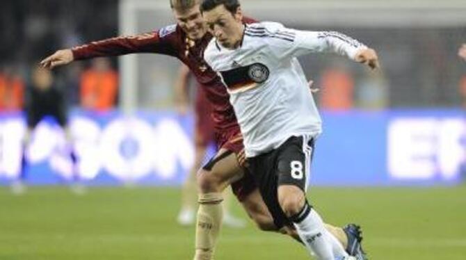 Vorbereiter des Siegtors: Mesut Özil im Zweikampf mit Igor Denissow. FOTO: DPA