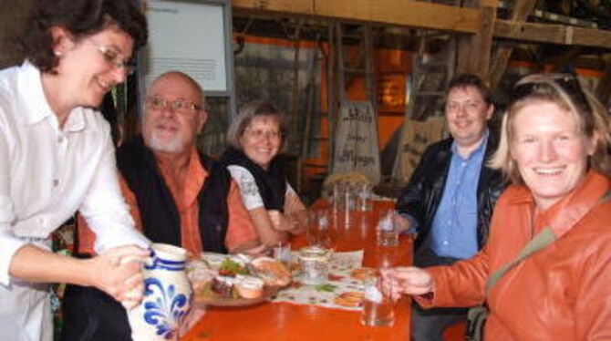 Yvonne Boss (links), Vorsitzende des Trachtenvereins, serviert Glemser Gästen Most und Vesperplatte im Obstbaumuseum.  FOTO: SAN