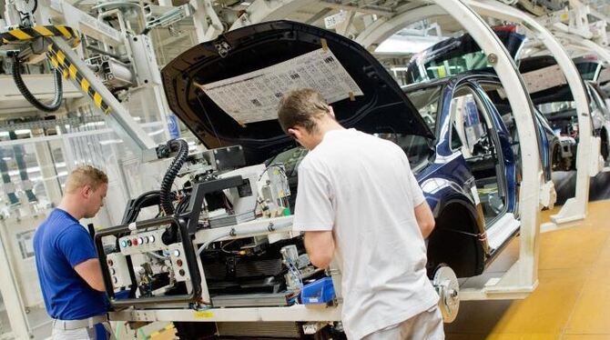 Mitarbeiter an einer Fertigungslinie des Golf VII im Volkswagen-Werk in Wolfsburg. Foto: Julian Stratenschulte/Archiv