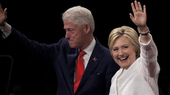 Hillary Clinton winkt zusammen mit ihrem Mann Bill ihren Anhängern zu. Foto: Peter Foley