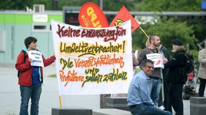 Demonstranten protestieren mit einem Plakat "Keine Entlastung für Umweltverbrecher! Die Verantwortlichen und Profiteure solle