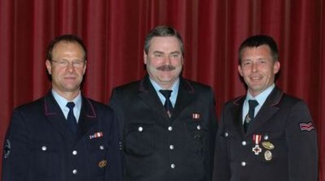 Kommandant Wilfried Boll (von links) mit Dietmar Schneck (30 Jahre Dienst) und Jörg Kautt (Ehrenzeichen in Silber).  
FOTO: ATH