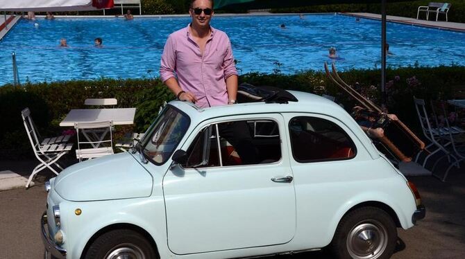 Hannes Hirsch mit seinem Fiat 500, der 29 Jahre älter ist als er selbst, vor idyllisch-sommerlicher Kulisse.